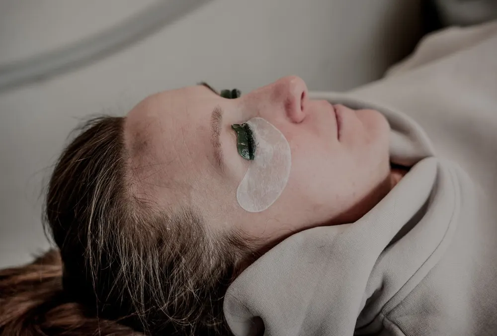 Eyelash extensions being applied at Skin and Beauty Box Bristol, with under-eye patches in place
