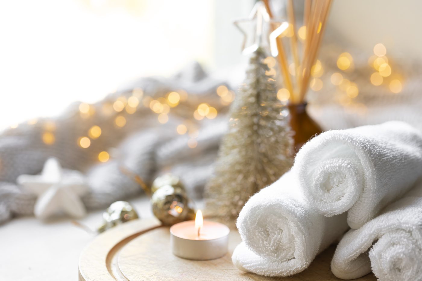 White spa towels, a lit candle and a small gold tree: a Christmas gift voucher idea from Skin & Beauty Box, Bristol